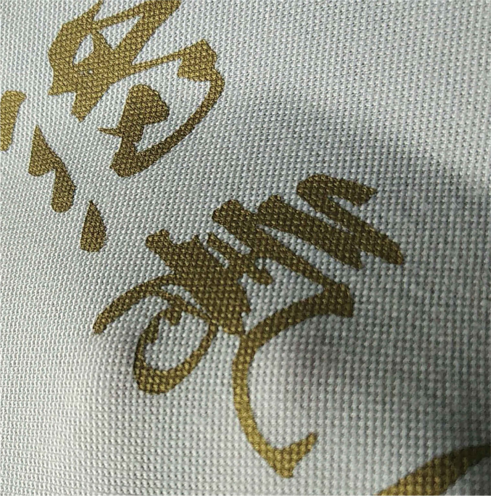 白色网眼布料上金色书法大字印花网点纹理
